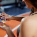 A fit sportswoman standing in a gym and taking pre workout pills.