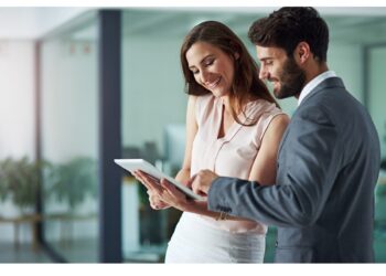 Shot of a young businessman and businesswoman using a digital tablet together in an office