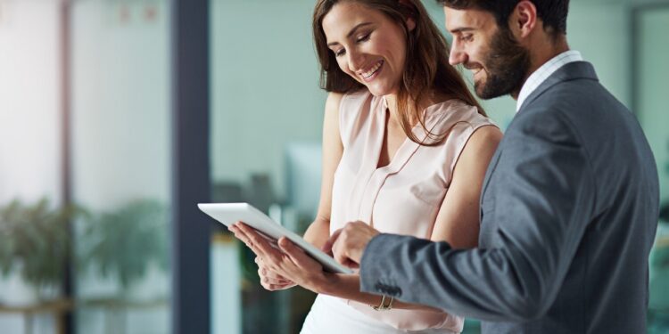 Shot of a young businessman and businesswoman using a digital tablet together in an office