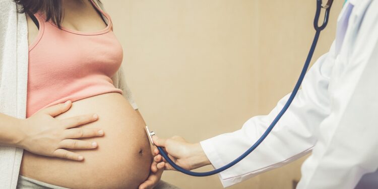 Happy pregnant woman visit gynecologist doctor at hospital or clinic for pregnancy consultant.