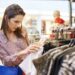 Young woman choosing blouse in the clothes shop