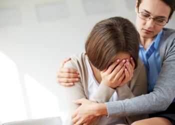 Image of compassionate psychiatrist comforting her crying patient