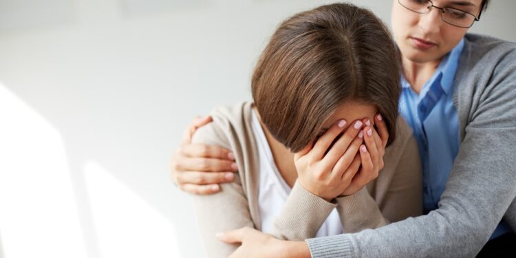 Image of compassionate psychiatrist comforting her crying patient