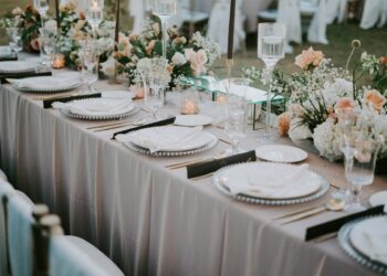 A decorated table setting with a floral design for a wedding celebration during daytime