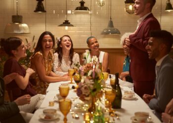 Two married girls having dinner party with their close friends as they listen to the best mans speech