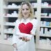 Pharmacist in white uniform holding medicines for cardiovascular disease.