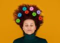 Neurophysiology, neuroscience, Brain, psychology, mental health, creativity, idea concept. Woman with gears in hair on orange background.