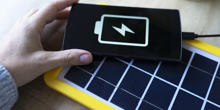 Renewable energy technology, solar panel charging a mobile phone battery