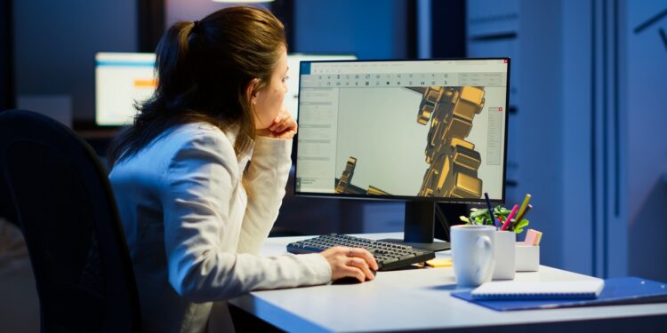 Tired woman architect working on modern cad program overtime sitting at desk in start-up office. Industrial female engineer studying prototype idea on pc showing cad software on device display