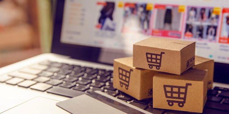 Shopping online concept - Shopping service on The online web. with payment by credit card and offers home delivery. parcel or Paper cartons with a shopping cart logo on a laptop keyboard