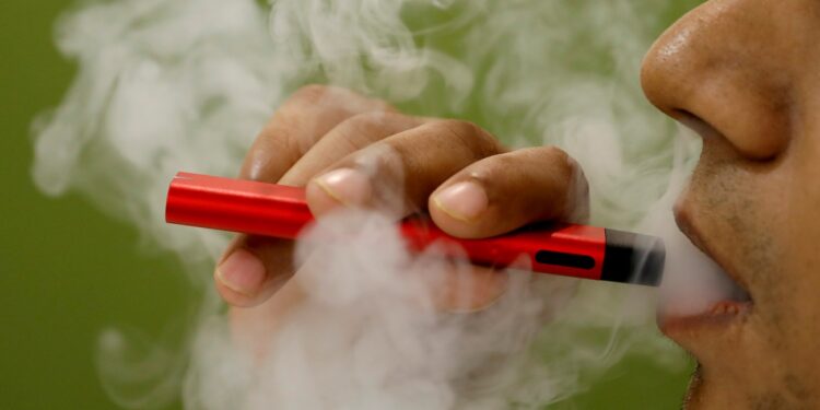FILE PHOTO: A man uses a vape device in this illustration picture, September 19, 2019. REUTERS/Adnan Abidi/Illustration/File Photo