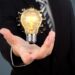 Business man holding light bulb