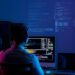 Developer working on code late at night, view from the back