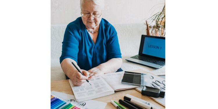 Hobby Ideas for Older People. Retirement Hobbies, Pastimes for Seniors. Activities for Seniors with Limited Mobility. Mature, elderly Senior Female Artist practices calligraphy and hand lettering