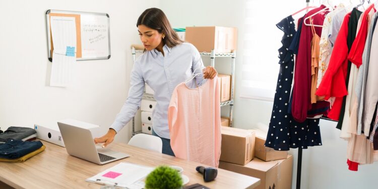 Young female entrepreneur running an online fashion business. Hispanic attractive woman preparing packages for customers' orders