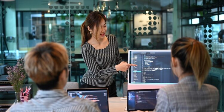 Young programmers and IT software developers team working in modern office. Concept of developing programming and coding technologies.