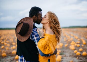 A young interracial couple kisses in a pumpkin field, close-up.; Shutterstock ID 1626962086; purchase_order: 09262022; job: Editorial Associate; client: Ellie Spencer-Failes; other: