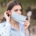 Portrait of a young and beautiful girl who puts on a medical mask on her face Health care