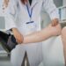 Physiotherapist checking hurt leg of senior man
