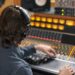 High angle at music producer operating audio workstation in professional recording studio, copy space
