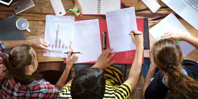Top view of multiethnic diverse group of young college students brainstorm discussion about medical document and search data on laptop, co-working education teamwork concept; Shutterstock ID 729962209; Ordering Party: -