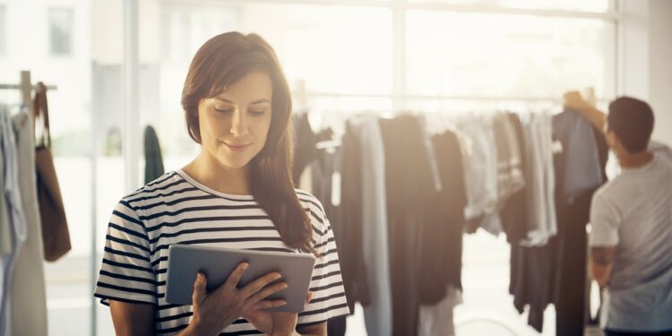 Shot of a boutique owner using a digital tablet with a customer blurred in the backgroundhttp://195.154.178.81/DATA/i_collage/pu/shoots/806285.jpg
