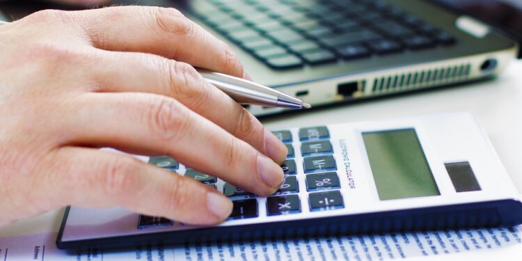 Detail of Business man in dark suit whit calculator