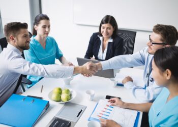 Doctors shaking hands with each other in meeting at conference room