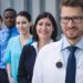 Portrait of smiling doctors standing in row at hospital premises