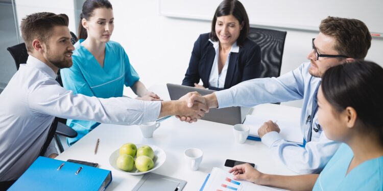 Doctors shaking hands with each other in meeting at conference room