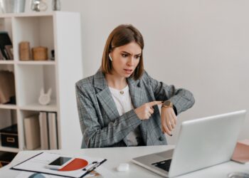 Dissatisfied lady boss talks on video and shows her watch, reminding her subordinates of deadline