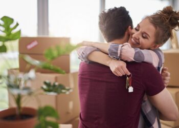 Happy couple with keys of new apartment