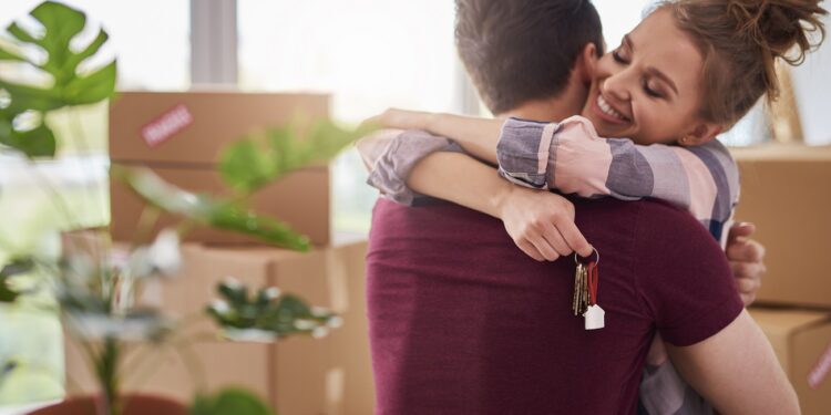 Happy couple with keys of new apartment