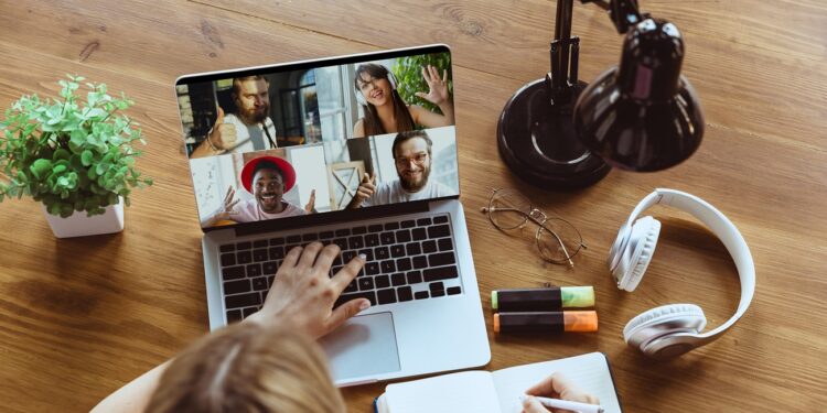 Remote meeting. Woman working from home during coronavirus or COVID-19 quarantine, remote office concept. Young boss, manager in front of laptop during online conference with colleagues and team.