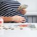 Close up of pregnant woman counting money