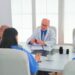 Team of doctors checking reports of patients, analysing waiting list and treatment development, nurse taking notes. Clinic expert therapist talking with colleagues about disease, medicine professional