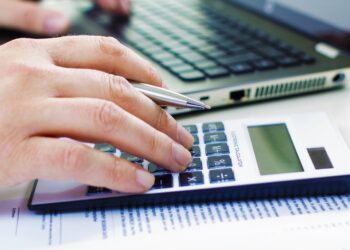 Detail of Business man in dark suit whit calculator