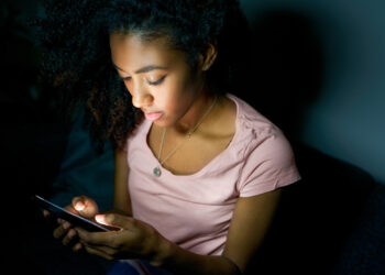 Lonely girl texting on mobile phone late at night