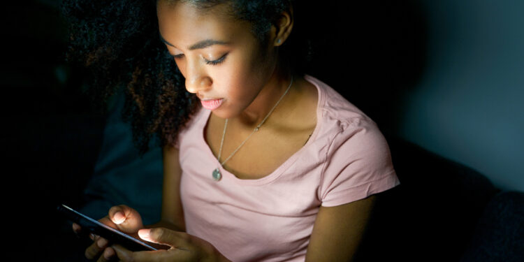 Lonely girl texting on mobile phone late at night