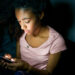 Lonely girl texting on mobile phone late at night