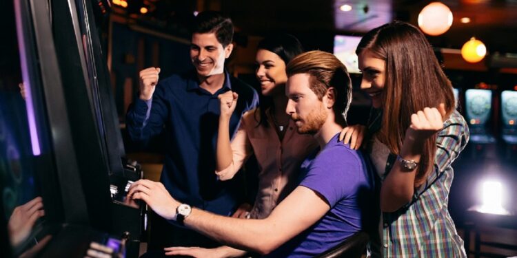 Young people at slot machine in the casino