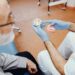 Handsome old man talking to the dendist. Two men in the dentist's office. The doctor shows the patient dentures