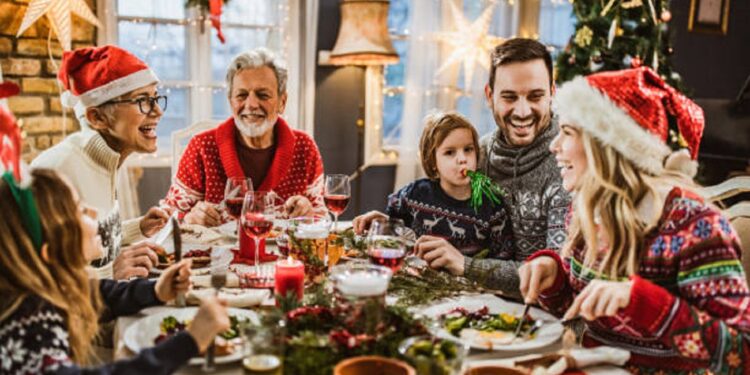 Happy multi-generation family talking while having New Year's meal at dining table.