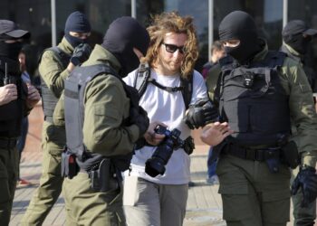 Police officers detain a photojournalist during an opposition rally to protest the official presidential election results in Minsk, Belarus, Saturday, Sept. 26, 2020. Hundreds of thousands of Belarusians have been protesting daily since the Aug. 9 presidential election. (AP Photo/TUT.by)