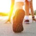 Athlete runner feet running on treadmill closeup on shoe.Mans fitness with the sun effect in the background and open space around him