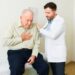 Caucasian old man feeling sick with heart problems coming into the doctor's office for a medical exam