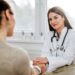 Friendly female doctor holding female patient's hand for encouragement and empathy.