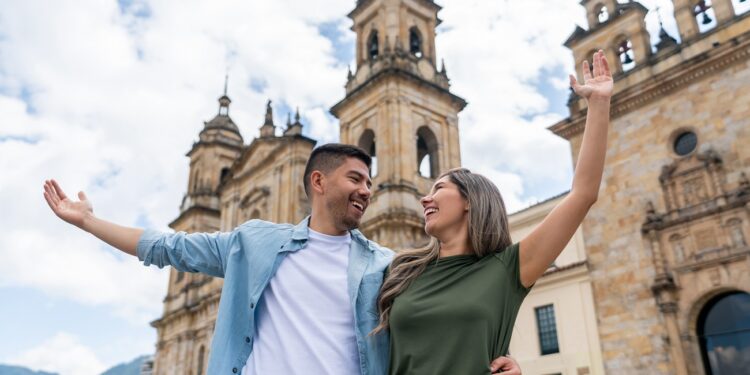 Latin American couple looking very happy sightseeing in Bogota at the Plaza de Bolivar - travel concepts