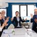 Motivated happy diverse business team people clapping celebrating success at corporate meeting. Multiethnical partners coworkers celebrate successful teamwork result at company briefing