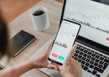 Forex trader using crypto exchange mobile phone app for investment and stock market analysis at hedge fund office - Focus on screen